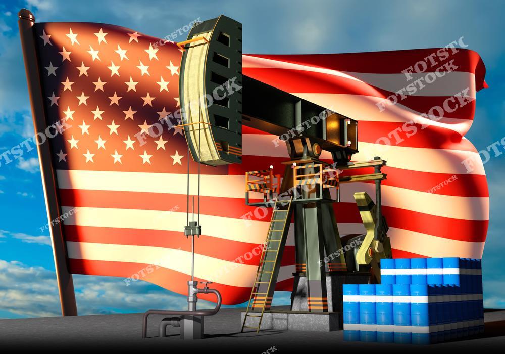 На изображении показана нефтяная качалка с бочками на фоне развевающегося флага Соединённых Штатов Америки. Фотография подчёркивает значимость нефтяной отрасли для экономики США. Элемент инфраструктуры иллюстрирует добычу, хранение и транспортировку нефти.